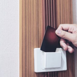 Man putting key card switch in hotel room controle-de-acesso-para-hoteis